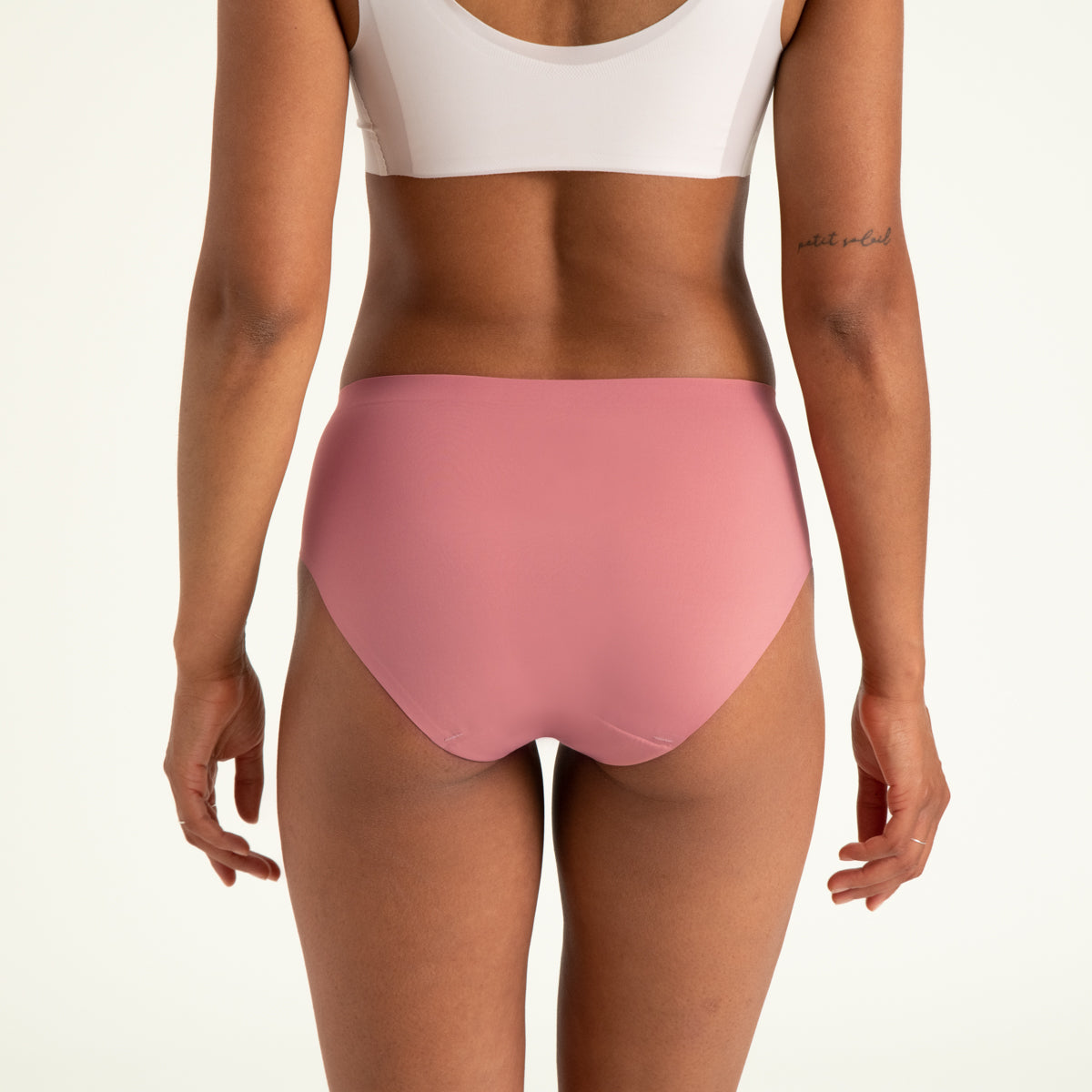 Modell trägt ooia Hipster Seamless in Dusky Pink – Periodenslip mit bequemer Passform und weichem, nahtlosem Stoff. Rückansicht.