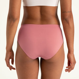 Modell trägt ooia Hipster Seamless in Dusky Pink – Periodenslip mit bequemer Passform und weichem, nahtlosem Stoff. Rückansicht.