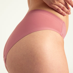 Modell trägt ooia Slip Seamless in Dusky Pink – nahtlose Periodenunterwäsche im klassischen Schnitt. Detailansicht.