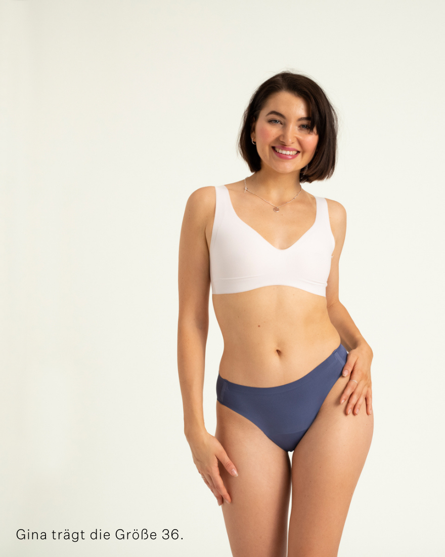 Modell trägt ooia Slip Seamless in Smoky Blue – nahtlose Periodenunterwäsche im klassischen Schnitt.