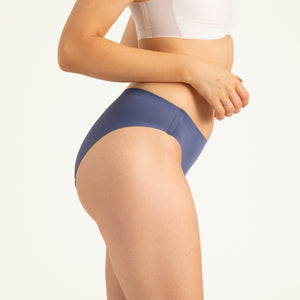 Modell trägt ooia Slip Seamless in Smoky Blue – nahtlose Periodenunterwäsche im klassischen Schnitt.