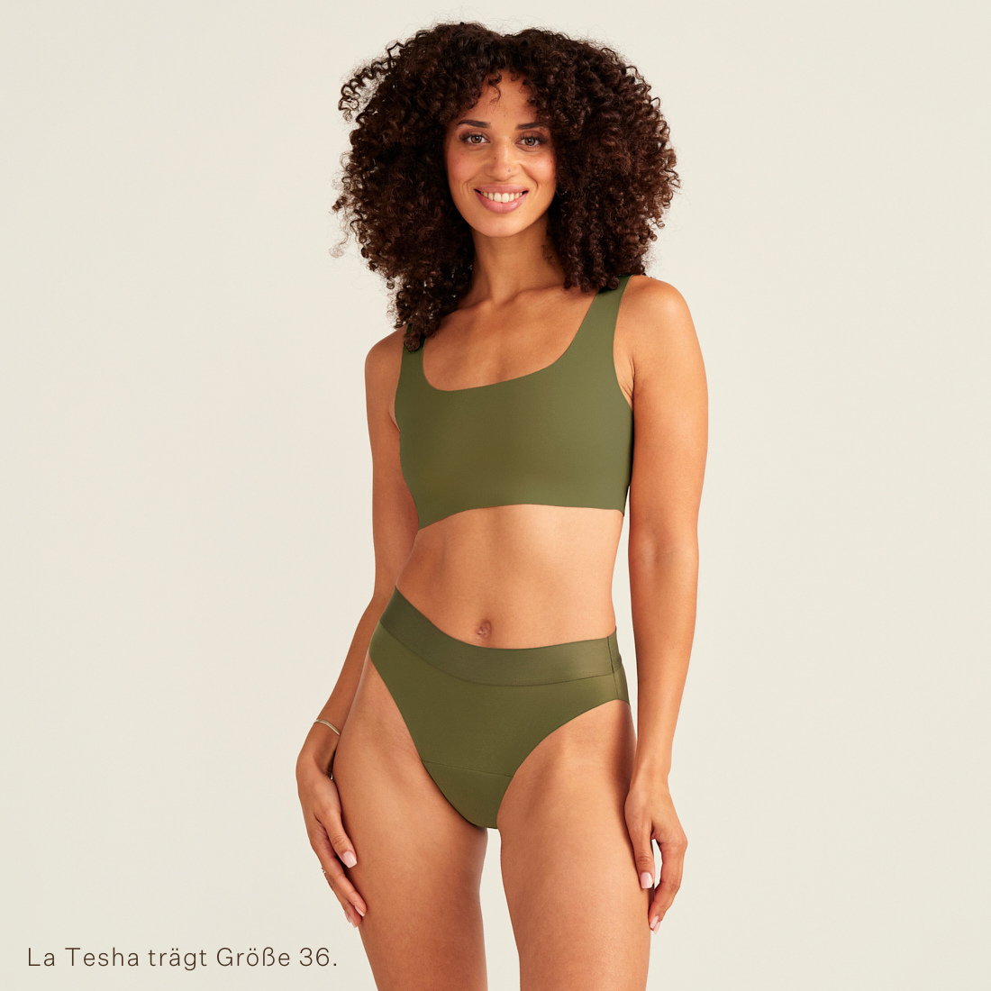 Modell trägt ooia Periodenslip Seamless Cheeky Periodenslip in Khaki mit hohem Beinausschnitt