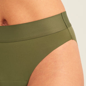 Modell trägt ooia Periodenslip Seamless Cheeky Periodenslip in Khaki mit hohem Beinausschnitt, Detailansicht nahtloser Bund