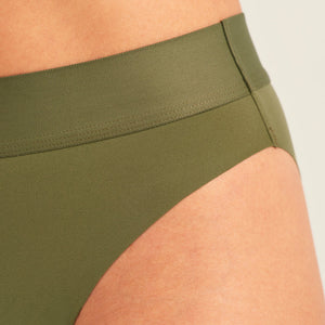 Modell trägt ooia Periodenslip Seamless Cheeky Periodenslip in Khaki mit hohem Beinausschnitt, Detailansicht nahtloser Bund