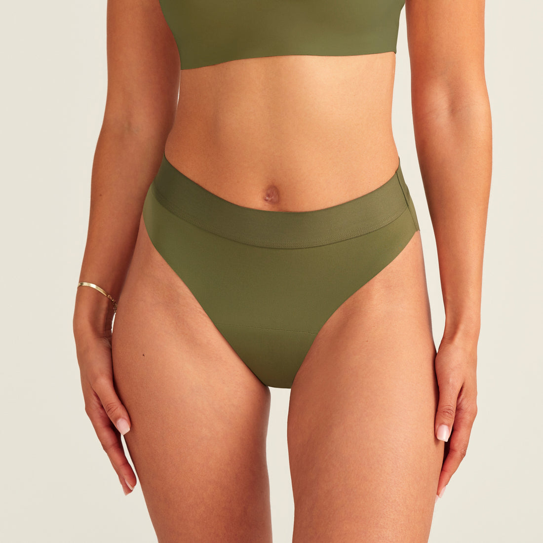 Modell trägt ooia Periodenslip Seamless Cheeky Periodenslip in Khaki mit hohem Beinausschnitt