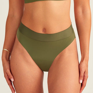 Modell trägt ooia Periodenslip Seamless Cheeky Periodenslip in Khaki mit hohem Beinausschnitt