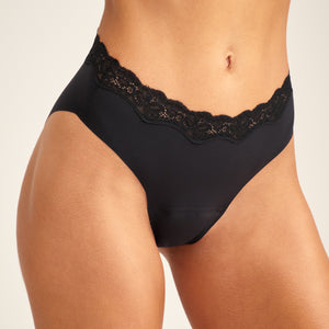 Modell trägt nahtlosen ooia Periodenunterwäsche Slip Seamless Lace Extra Strong in schwarz