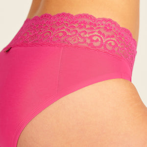 Modell trägt ooia Slip Extra Strong in hot pink mit Spitze am Bund – Periodenunterwäsche für starke Tage, Detailansicht