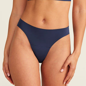 Modell trägt den ooia Periodenunterwäsche String Seamless in midnight mit leichter Saugstärke