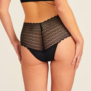 Modell trägt ooia Highwaist Comfy Lace in Schwarz – Periodenunterwäsche mit hohem Bund und durchgängiger Spitze. Rückansicht.