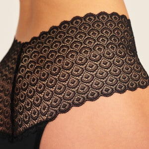Modell trägt ooia Highwaist Comfy Lace in Schwarz – Periodenunterwäsche mit hohem Bund und durchgängiger Spitze. Detailansicht.
