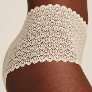 Modell trägt ooia Highwaist Comfy Lace in Ivory - Periodenunterwäsche mit hohem Bund und durchgängiger Spitze. Detailansicht.