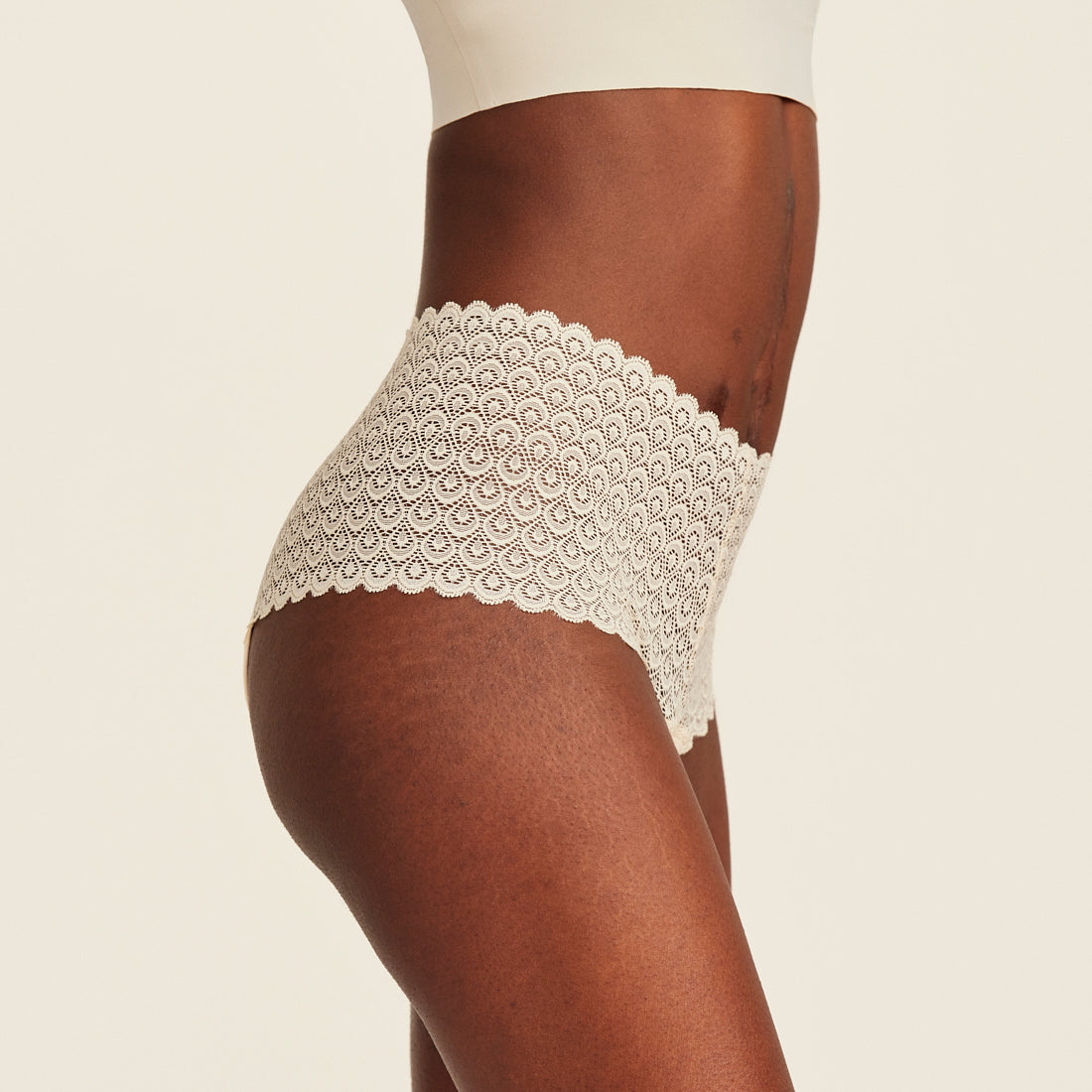 Modell trägt ooia Highwaist Comfy Lace in Ivory - Periodenunterwäsche mit hohem Bund und durchgängiger Spitze.