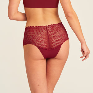 Modell trägt ooia Periodenunterwäsche Highwaist Comfy Lace in merlot, mit durchgängiger, elastischer Spitze. Rückansicht.