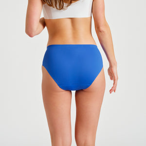 Modell trägt ooia Hipster Seamless in bold blue - nahtlose Periodenunterwäsche. Rückansicht.