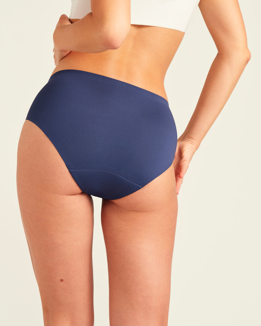 Modell trägt ooia Hipster Seamless in Midnight - nahtlose Periodenunterwäsche. Rückansicht.