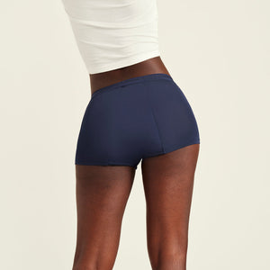 Modell trägt ooia Shorty Extra Strong in Midnight – Periodenunterwäsche im sportlichen Schnitt mit hoher Saugkraft. Rückansicht