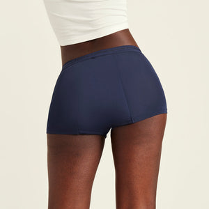 Modell trägt ooia Shorty Extra Strong in Midnight – Periodenunterwäsche im sportlichen Schnitt mit hoher Saugkraft. Rückansicht
