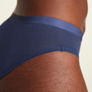 Modell trägt ooia Slip Basic Extra Strong in Midnight – Periodenunterwäsche im klassischen Schnitt mit extra starker Saugkraft. Detailansicht.
