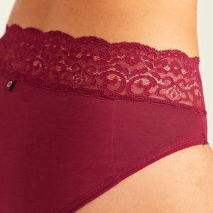 Modell trägt ooia Periodenslip in Merlot, mit extra starker Saugstärke und breiter Spitze am Bund. Detailansicht.