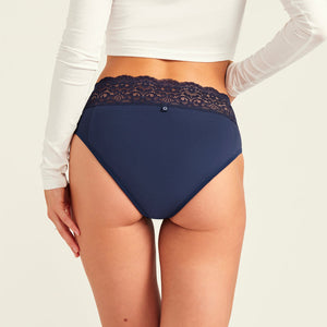 Modell trägt ooia Periodenslip Extra Strong in Midnight mit breiter Spitze am Bund. Rückansicht.