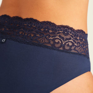 Modell trägt ooia Periodenslip Extra Strong in Midnight mit breiter Spitze am Bund. Detailansicht der Spitze