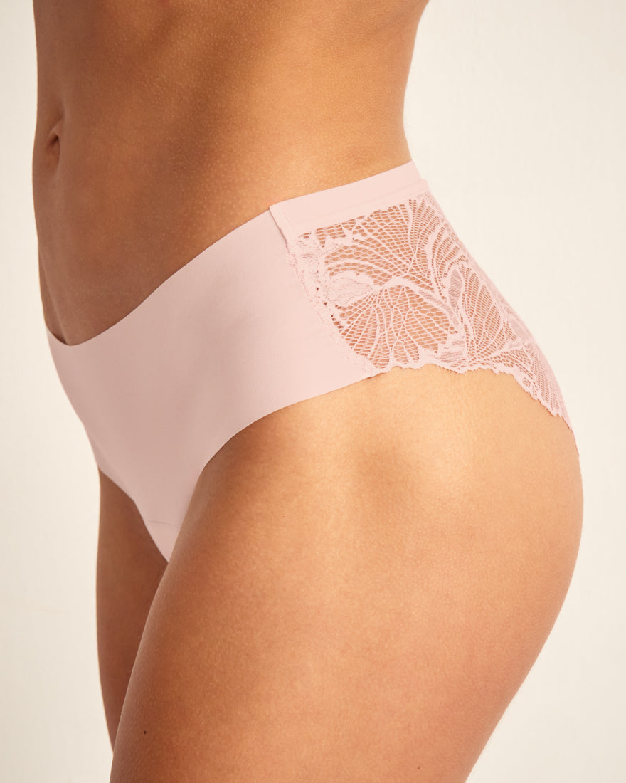 Modell trägt ooia Hipster Seamless Lace in Powder Rose – Periodenunterwäsche mit nahtloser Front und Spitze am Gesäß.
