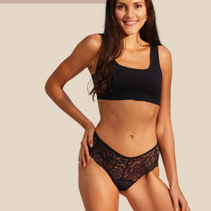 Modell trägt ooia Hipster Allover Lace in Schwarz – elegante Periodenunterwäsche mit durchgehender Spitze.