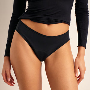 Modell trägt ooia Periodenunterwäsche Slip Comfy Cotton in schwarz aus Baumwolle.
Frontal