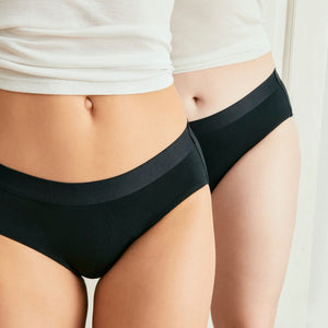 Zwei Models tragen ooia everyday Hipster in Schwarz – Unterwäsche mit breitem Bund, die Slipeinlagen ersetzt.