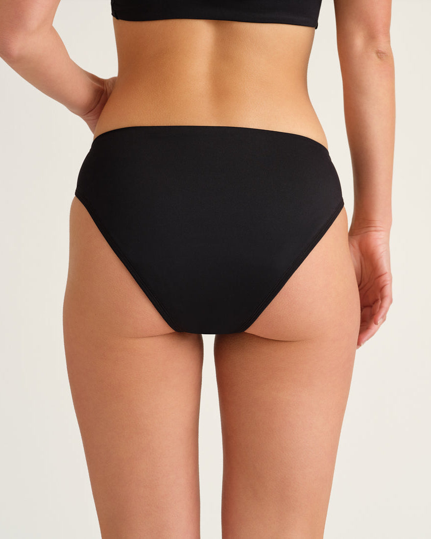 Hip-shot von hinten, eine Frau die einen Schwarzen Perioden Badeanzug Slip von Ooia trägt