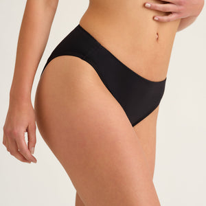 Seitliches Hip-shot von einer Frau, die einen Schwarzen Perioden Badeanzug Slip von Ooia trägt