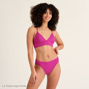 Lächelnde Frau trägt den Pinken Perioden Badeanzug Slip und Top von Ooia