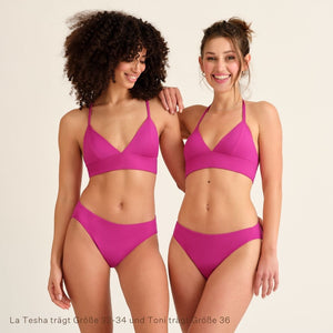 Zwei lächelnde Frauen trägen den Pinken Perioden Badeanzug Slip und Top von Ooia