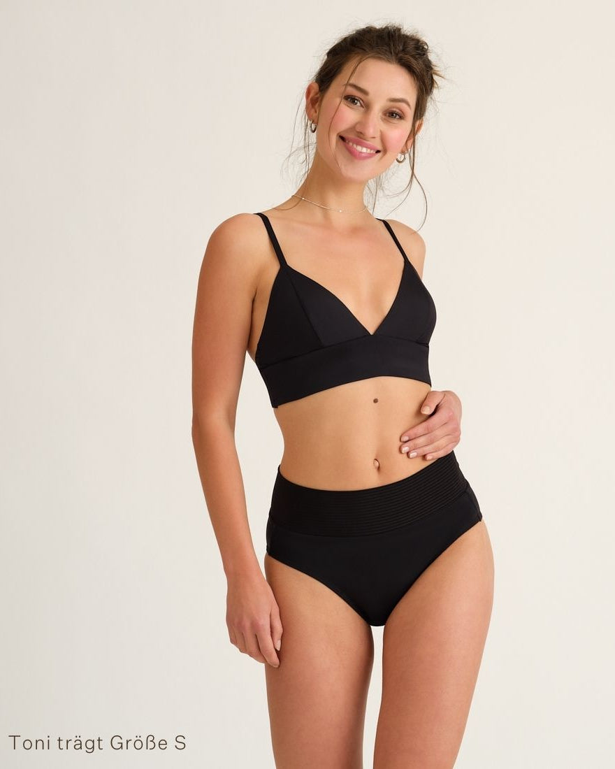 Modell trägt das ooia Beach Triangle Top in Schwarz – Bikini-Oberteil mit verstellbaren Trägern im klassischen Triangel-Design.