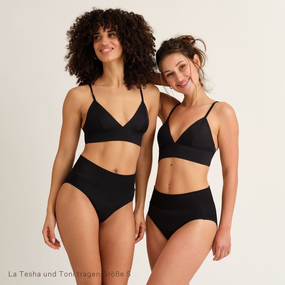 Zwei Models tragen Modell trägt das ooia Beach Triangle Top in Schwarz – Bikini-Oberteil mit verstellbaren Trägern im klassischen Triangel-Design
