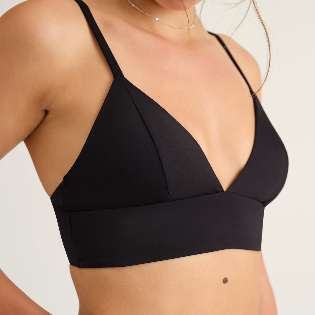 Modell trägt das ooia Beach Triangle Top in Schwarz – Bikini-Oberteil mit verstellbaren Trägern im klassischen Triangel-Design.