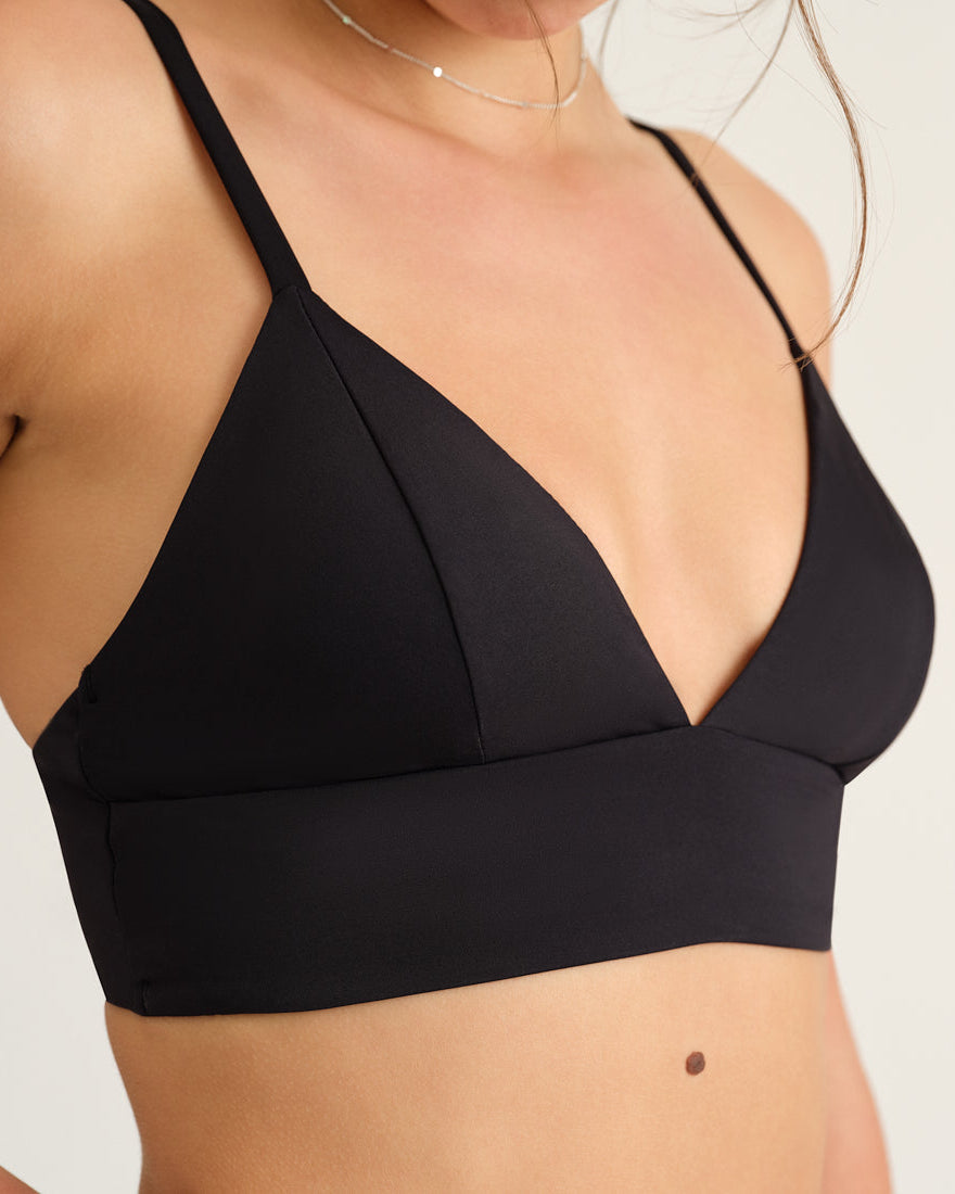 Modell trägt das ooia Beach Triangle Top in Schwarz – Bikini-Oberteil mit verstellbaren Trägern im klassischen Triangel-Design.