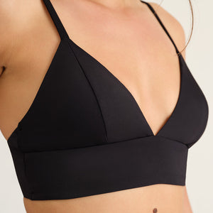 Modell trägt das ooia Beach Triangle Top in Schwarz – Bikini-Oberteil mit verstellbaren Trägern im klassischen Triangel-Design.