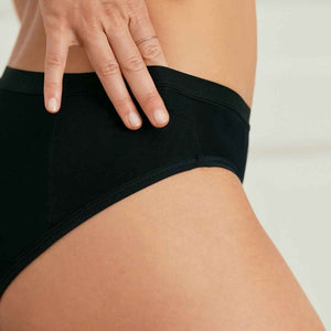 Modell trägt ooia Slip Basic Extra Strong in Schwarz – Periodenunterwäsche im klassischen Design mit hoher Saugstärke. Detailansicht.