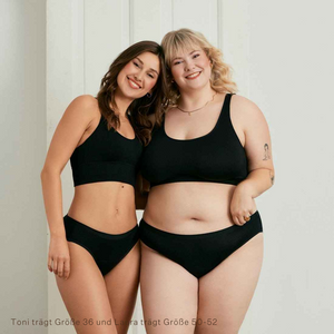 Zwei Models unterschiedlicher Konfektion tragen ooia Slip Basic Extra Strong in Schwarz – Periodenunterwäsche im klassischen Design mit hoher Saugstärke.