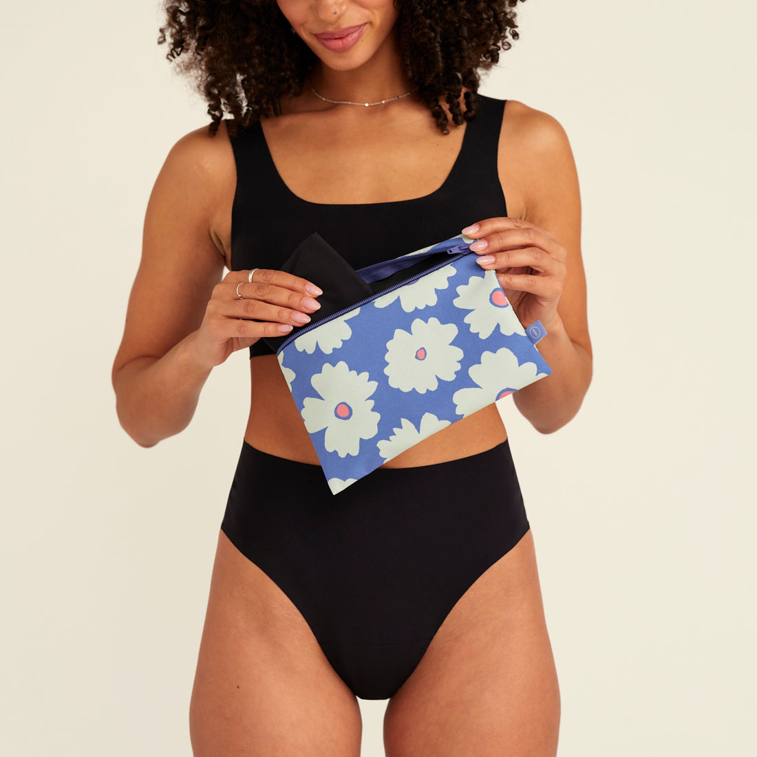 Modell tut einen Periodenslip in die ooia Wetbag Edition 24/25, mit Daisy Aufdruck und flüssigkeitsundurchlässigem Innenstoff