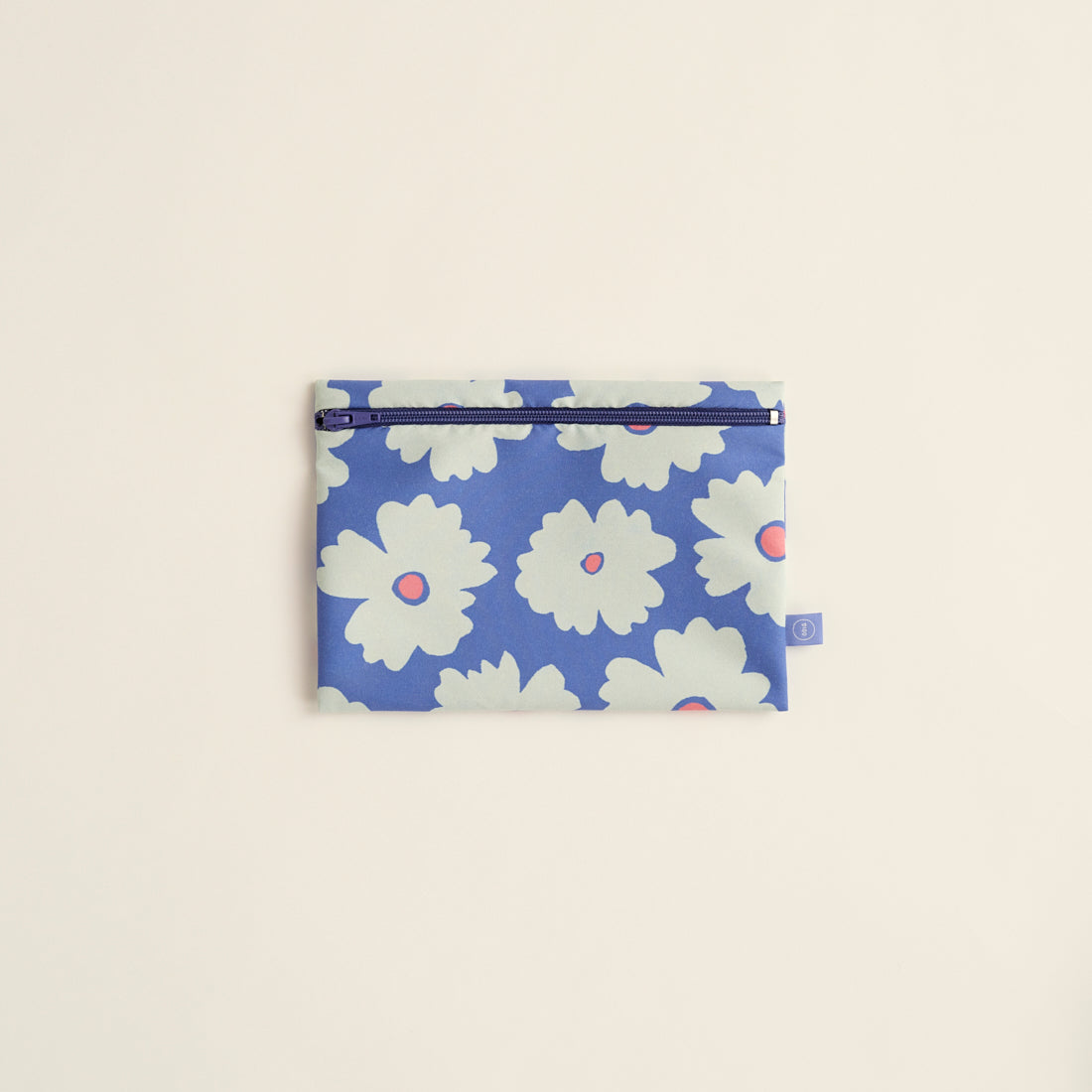 ooia Wetbag Edition 24/25, mit Daisy Aufdruck und flüssigkeitsundurchlässigem Innenstoff liegt auf einer hellen Fläche