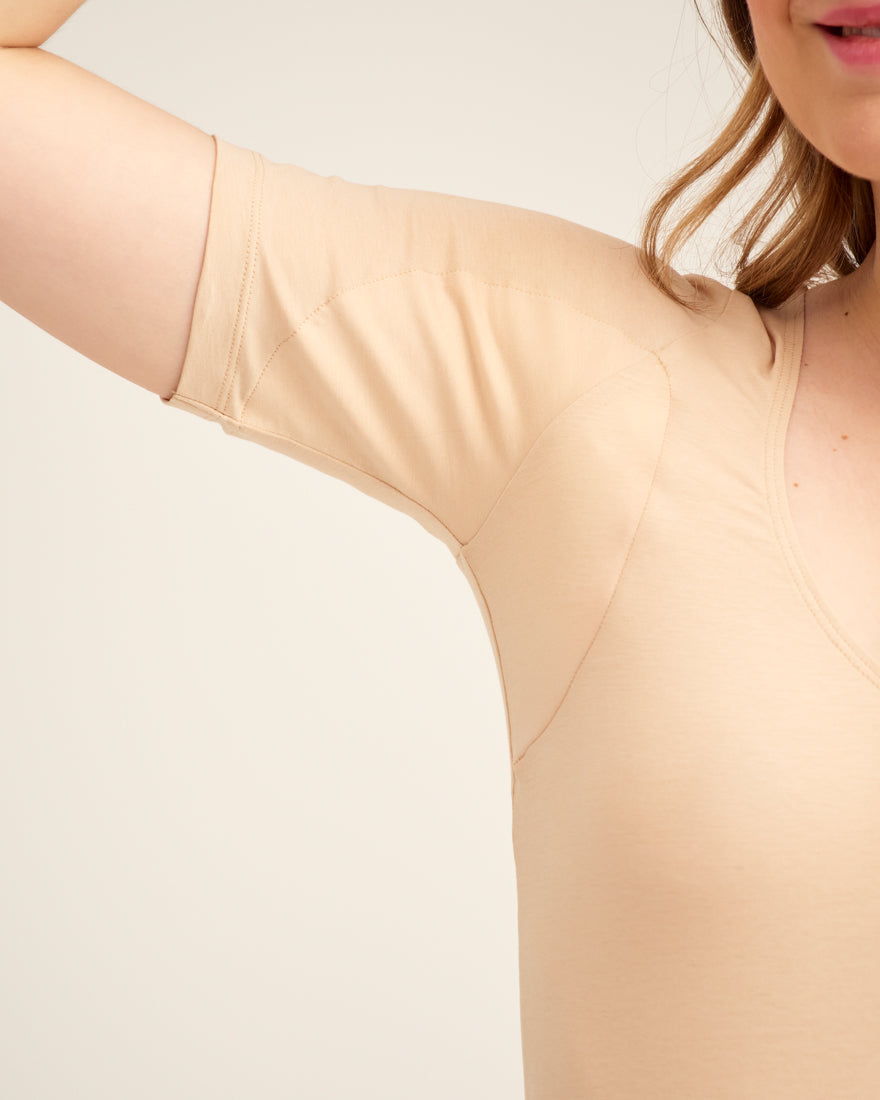 Modell trägt ooia Feel Dry Top in Beige – figurbetontes Top mit integrierter Saugfunktion für Schweiß. Detailansicht Achselbereich.