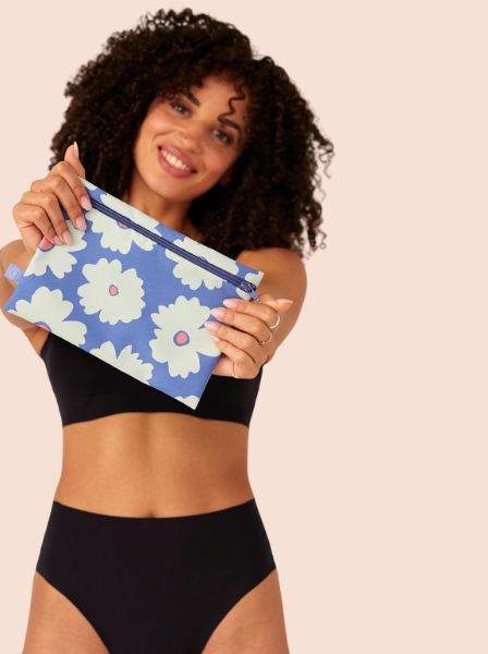 Model trägt schwarze nahtlose Periodenunterwäsche und hält eine Wetbag in die Kamera