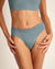 Modell trägt Periodenunterwäsche Slip Seamless Lace extra stark in blau mit nahtlosem Design mit Spitze am Bund.
Fronansicht, Nah