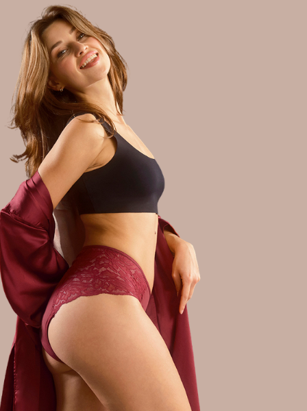 Zwei Models stehen Rücken an Rücken in Lace Periodenslips in rot und grün.