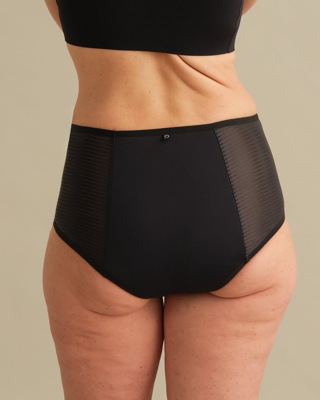 Model trägt ooia Inkontinenz Highwaist Slip in schwarz.
back