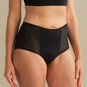 Model trägt ooia Inkontinenz Highwaist Slip in schwarz.
Frontal