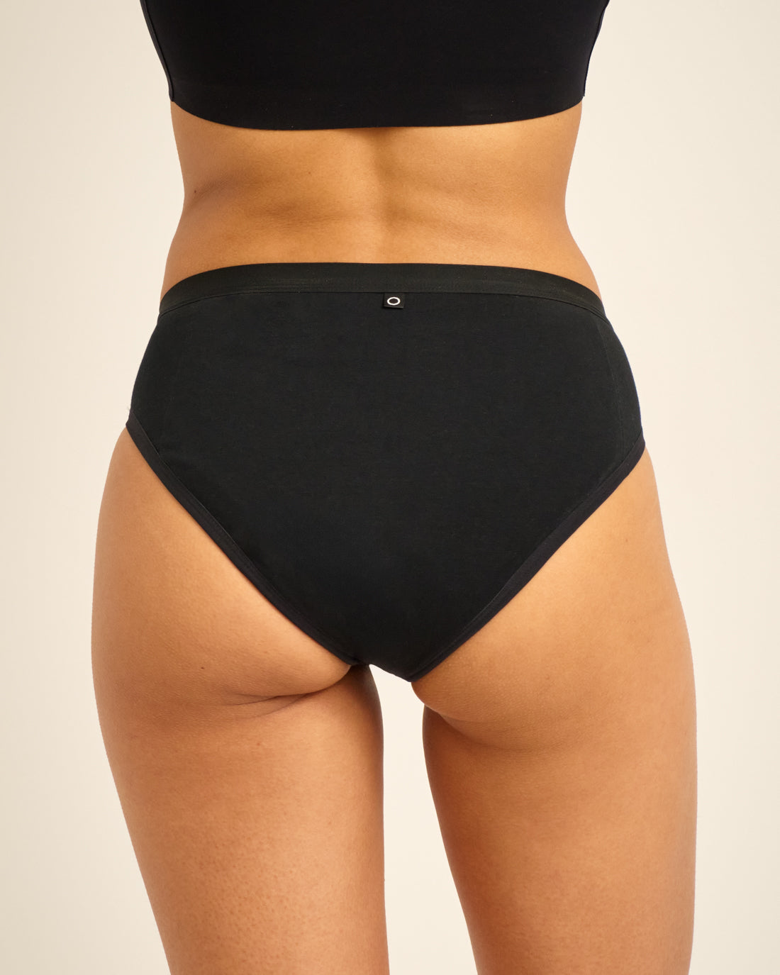 Modell trägt ooia Slip Basic Extra Strong in Schwarz – Periodenunterwäsche im klassischen Design aus Baumwolle mit hoher Saugstärke.
hinten